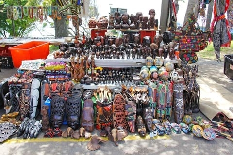 Various african fabrics, paintings and pottery exposed on a market stand